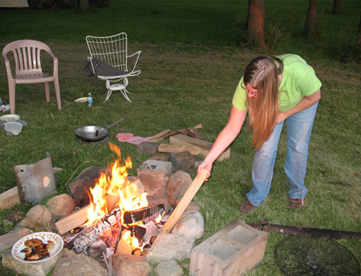 Rachel Baker tending the fire pit