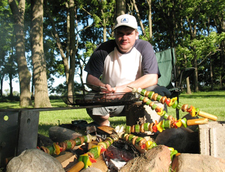 Jared gets vegetable kabobs ready for the fire