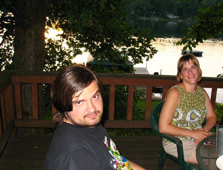 Kevin and Rachel posing for the camera, the lake shimmering in the background