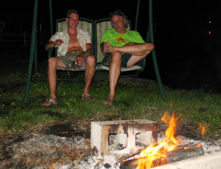 Two artists watching the fire, listening to students share their day's productions