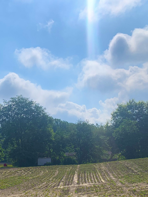 Sunlight streaming through clouds onto a desiccated field