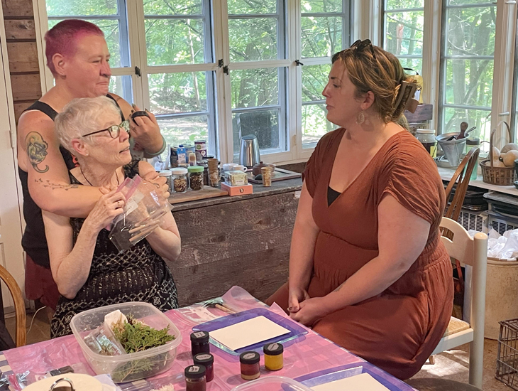 Bex Miller, Mary Catherine Harper, and Cait West at the table of eco-art supplies