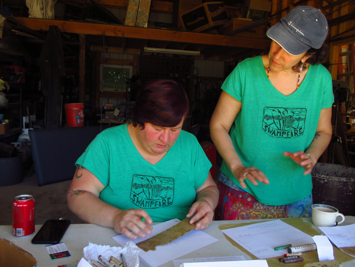 Mey watches as Bex draws on paper made by Mey for her "Naming Our Grandmothers" project.